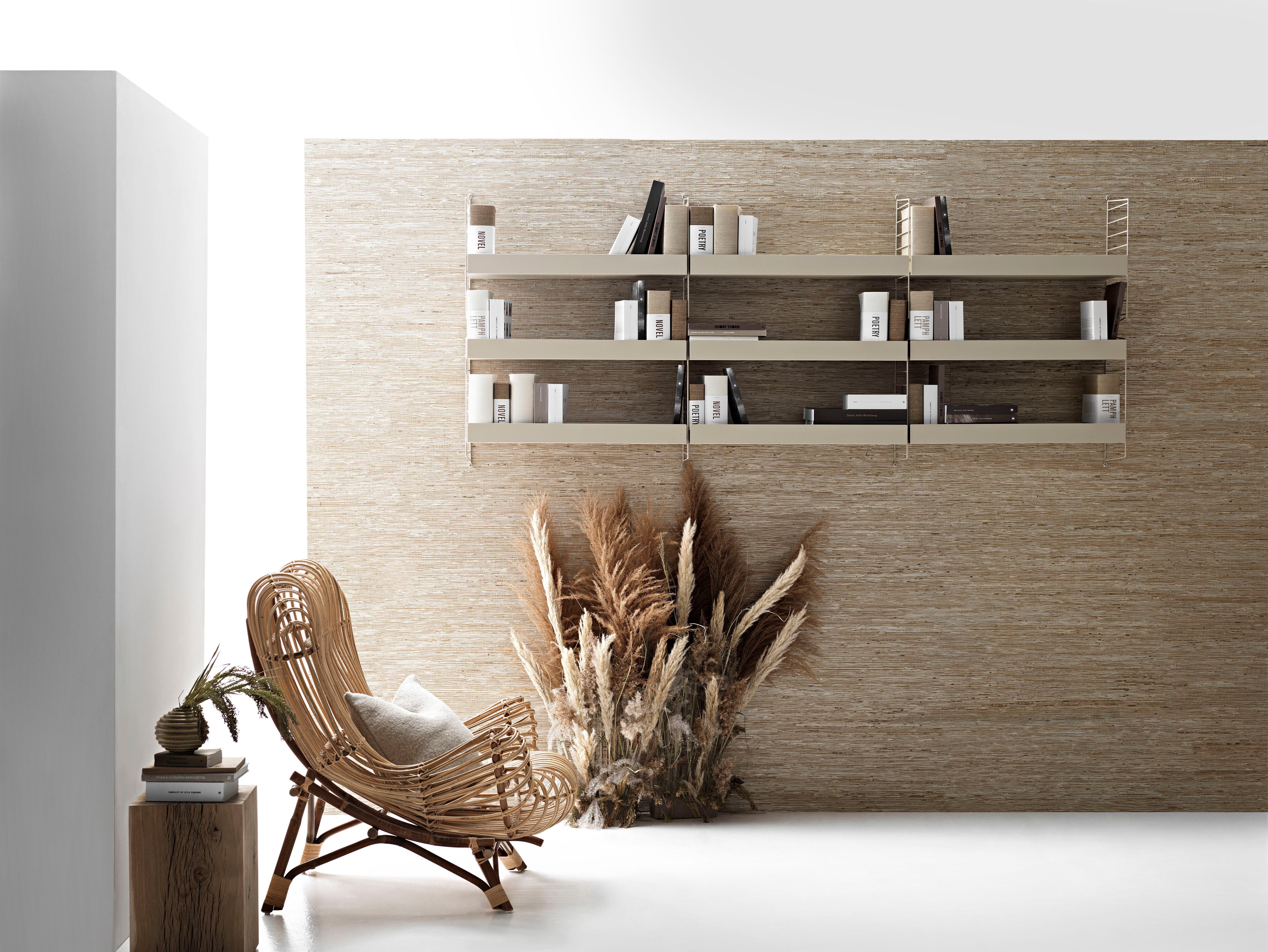 Wall mounted living room solution from String.
Wall panels and metal shelves high in beige.