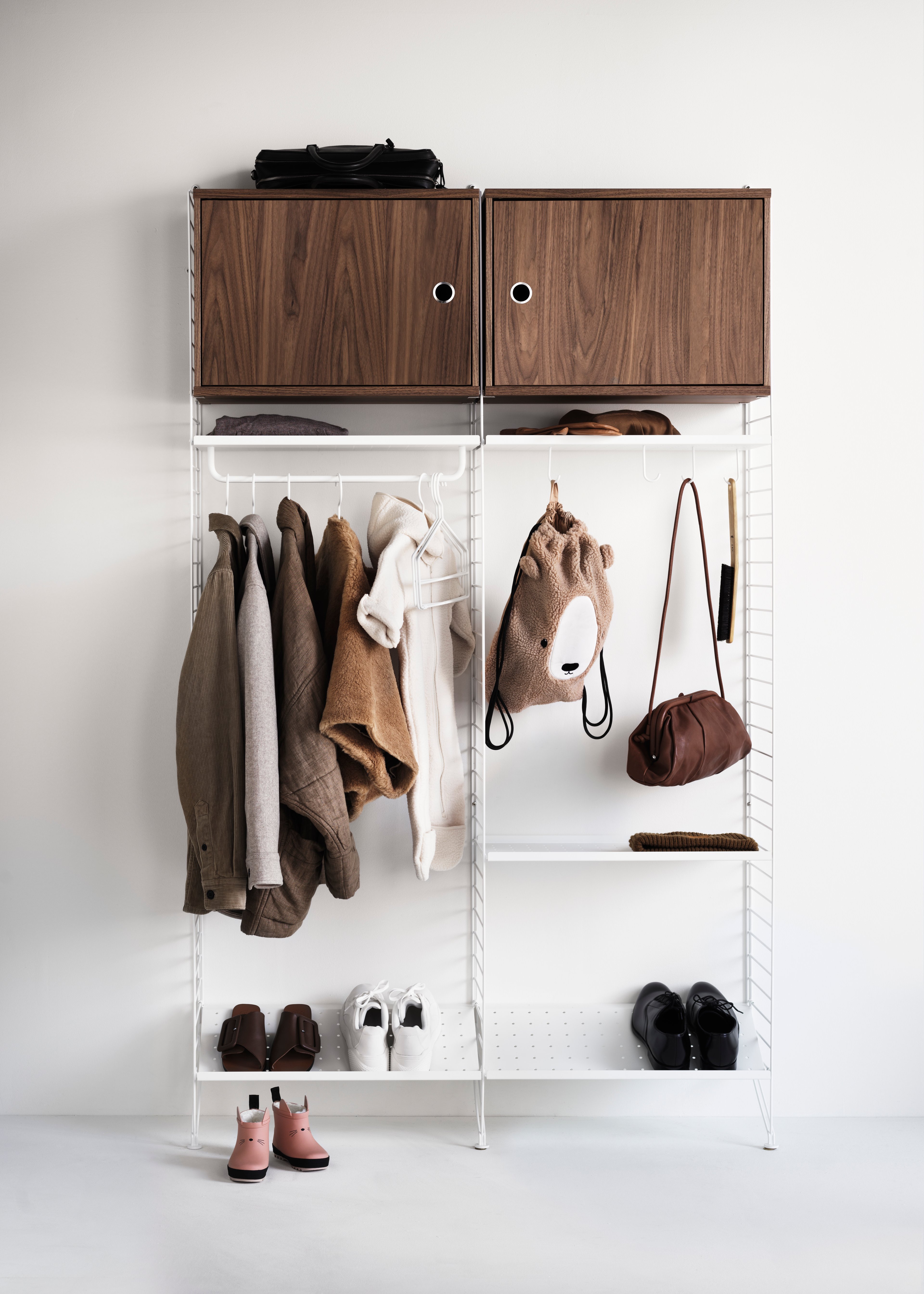 String shelf optimal for your hallway. Floor panels, metal shelves and shoe shelves, rods and hooks in white. Cabinets with swing door in walnut.