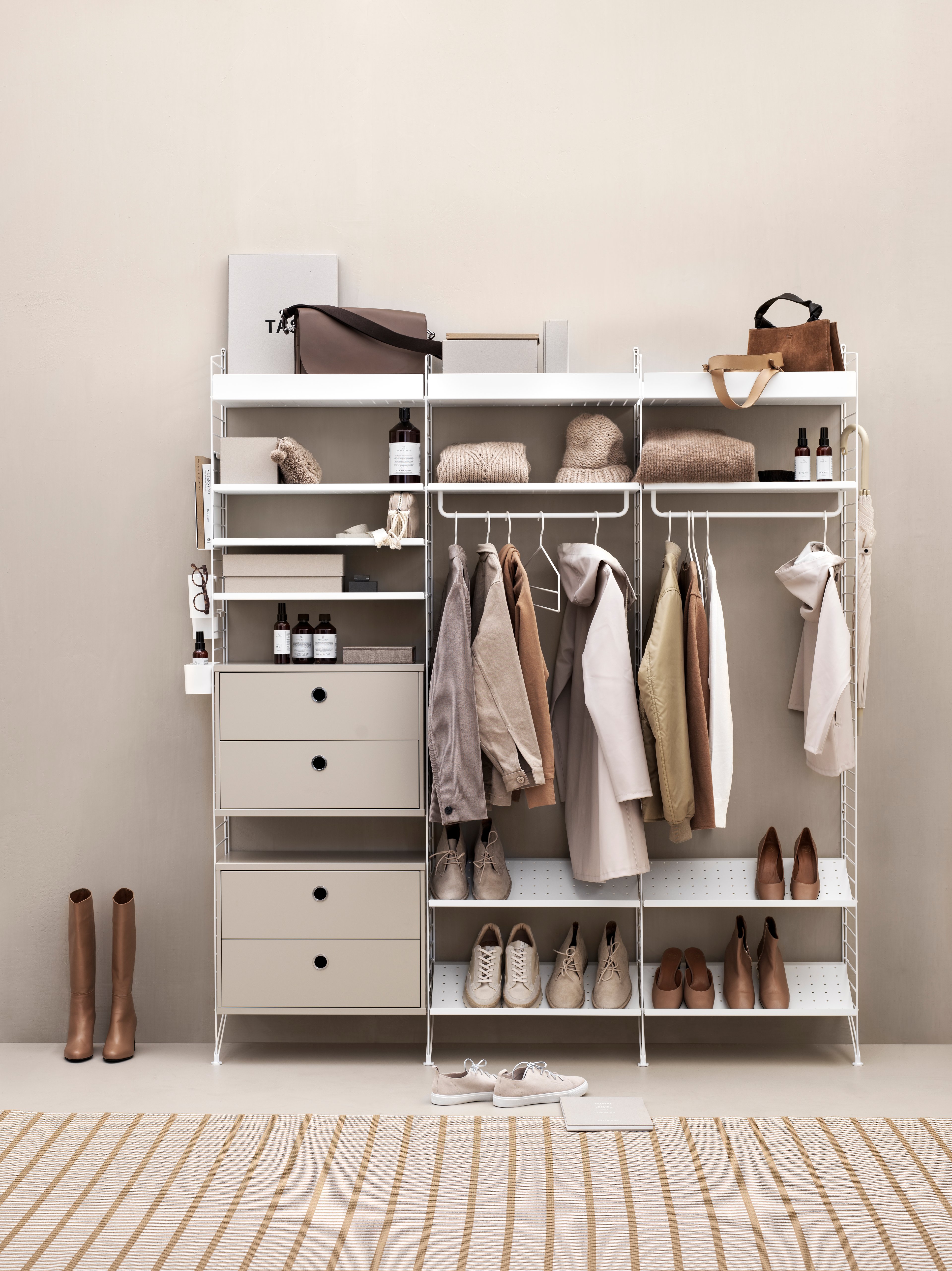 Hallway combination from String shelving system. Floor panels, metal shelves low, metal shelves high and shoe shelves in white. Chest of drawers in ash. Magazine holder, coat hangers, rod, hangers and hooks in white.