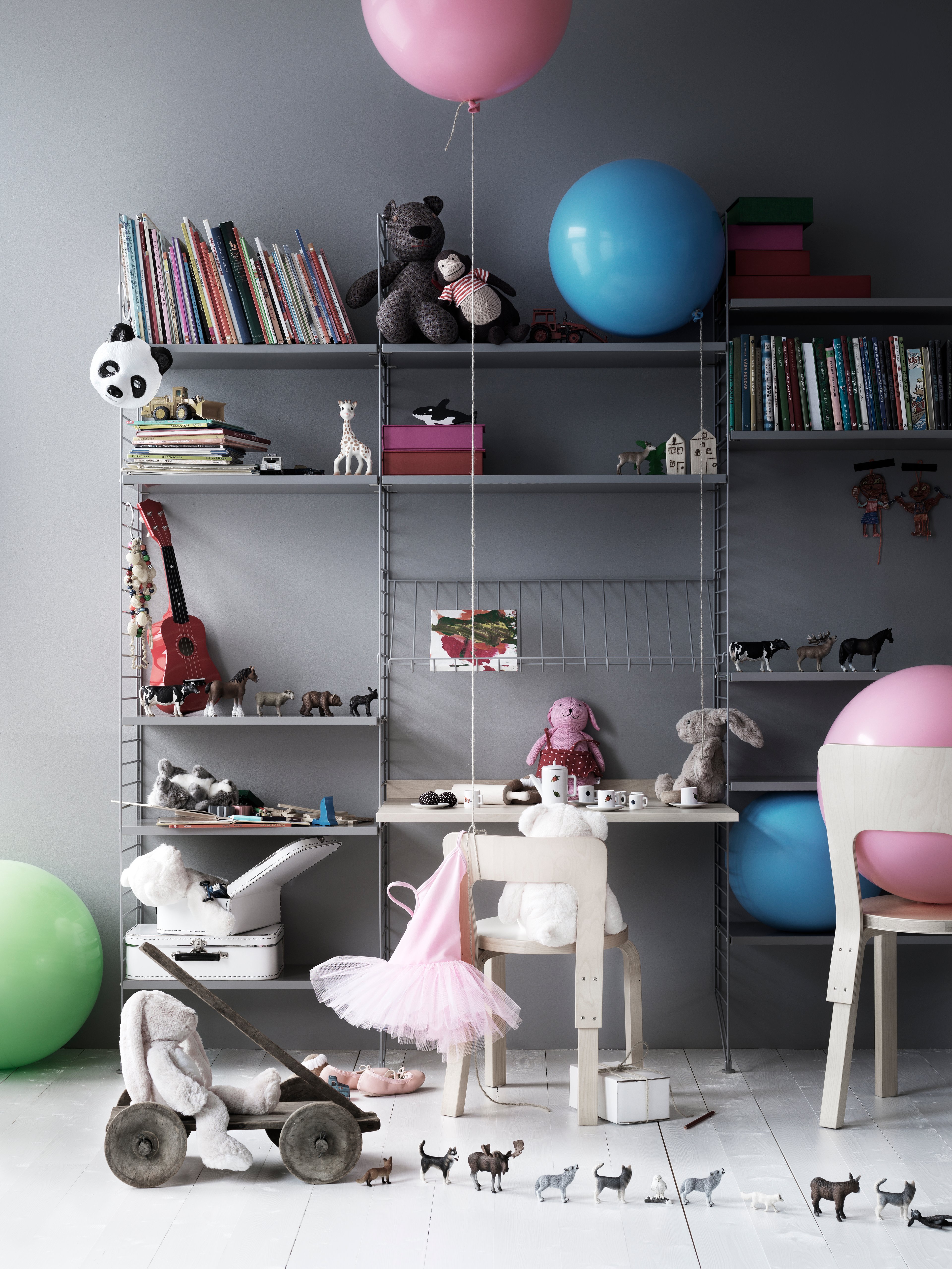 Floor mounted kidsroom solution from String. Floor panels, shelves, magazine shelf metal in grey. Work desk in ash.