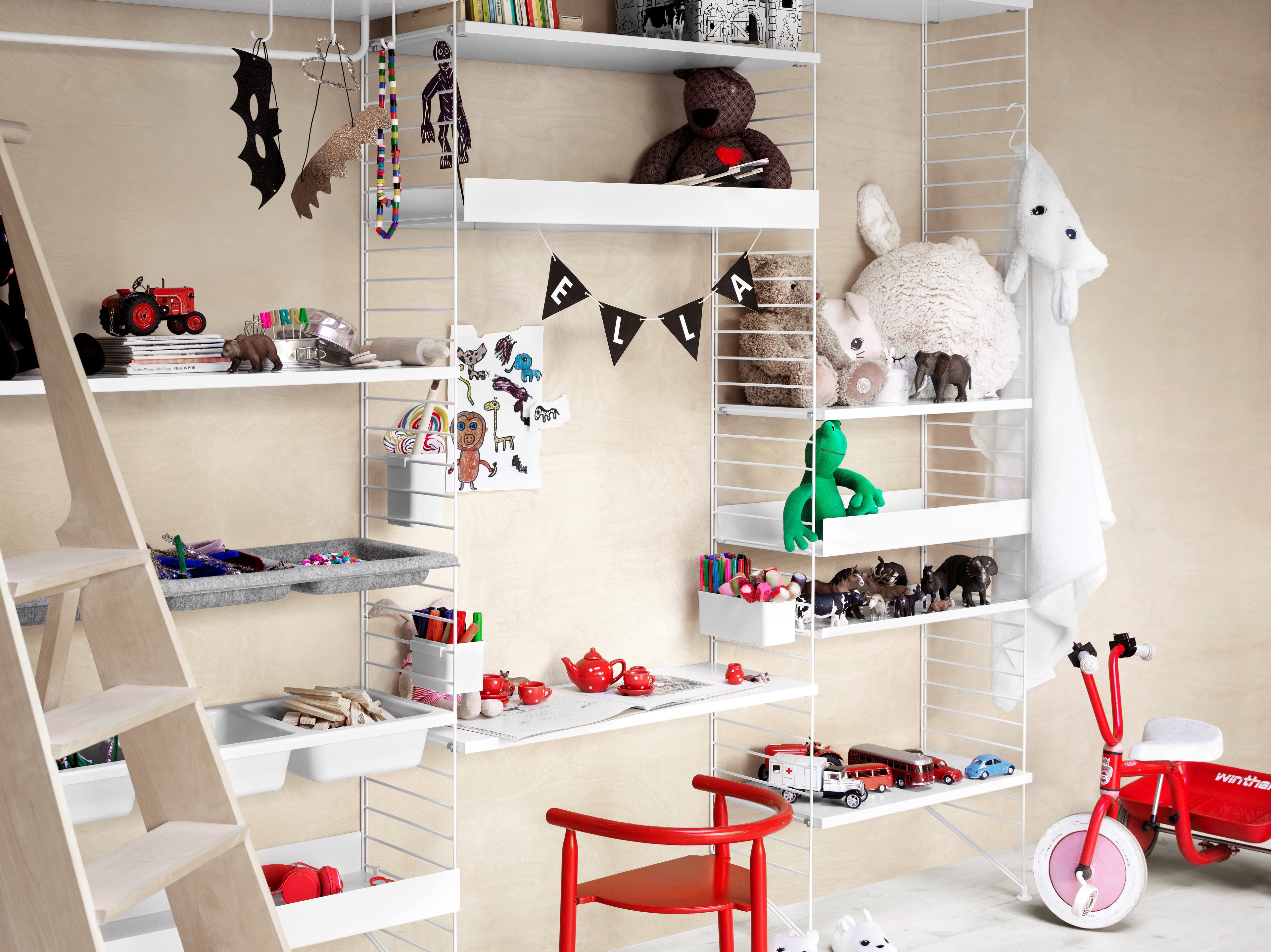 Floor mounted kidsroom solution from String. Floor panels, shelves and work desks in white. Bowl shelf in white and bowl shelves in light grey felt. Metal shelves high and metal shelves low in white. Organizers in white.