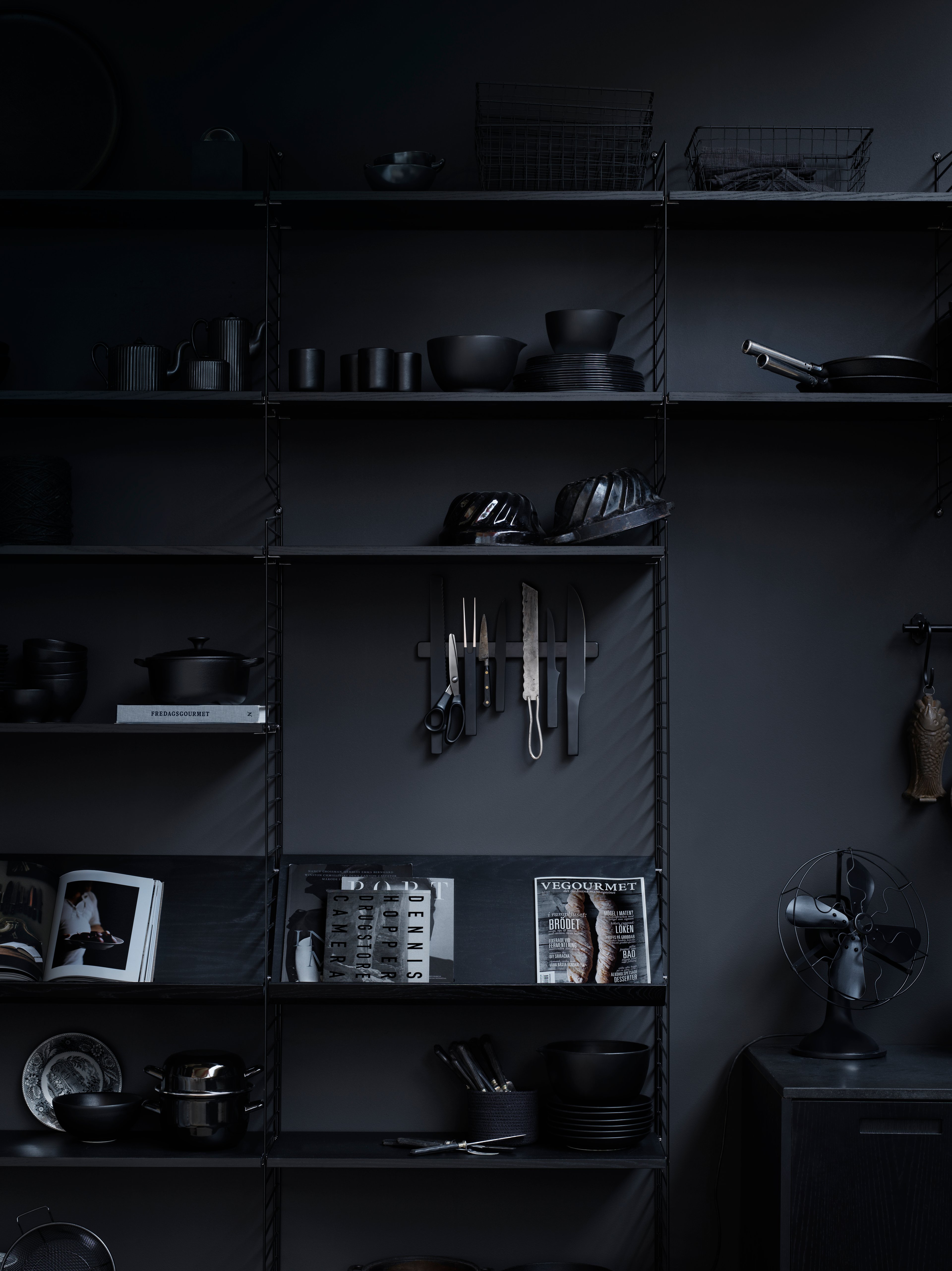 Floor mounted kitchen solution from String. Floor panels and shelves in black stained ash. Magazine shelves solid in black stained ash.