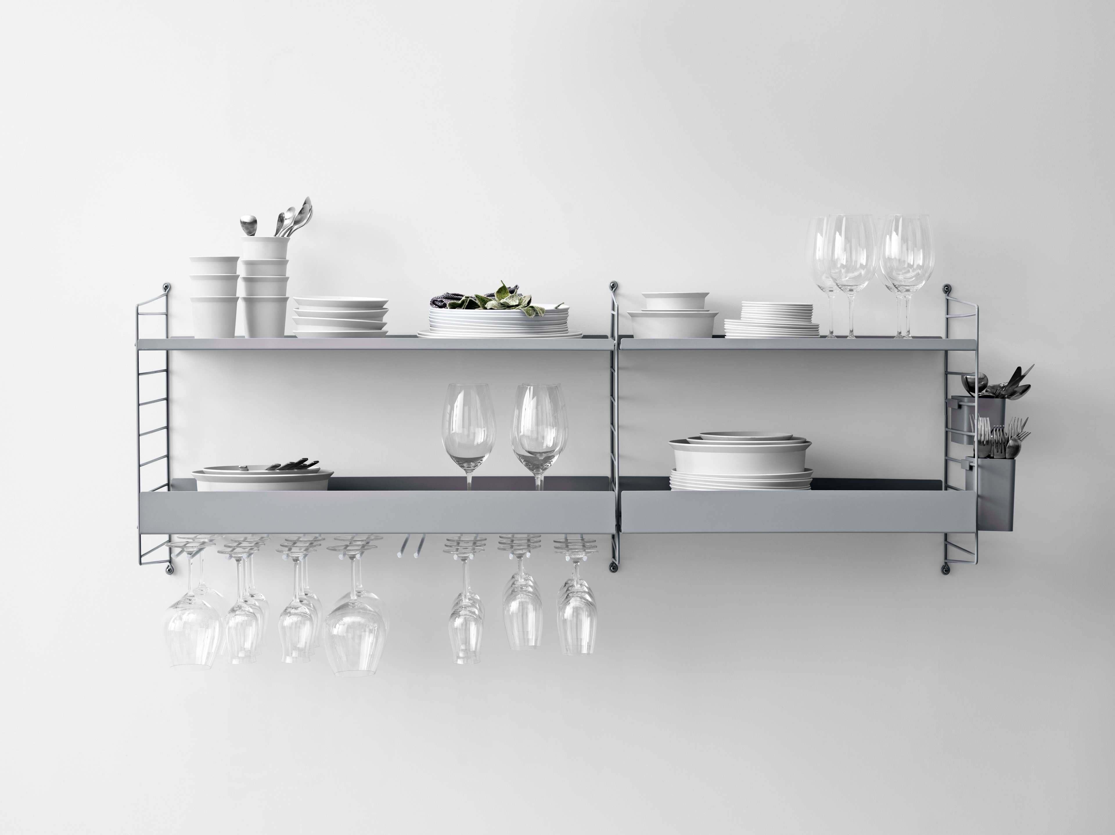 Wall mounted kitchen solution from String. Wall panels, metal shelves, hanger racks and organizers in grey.