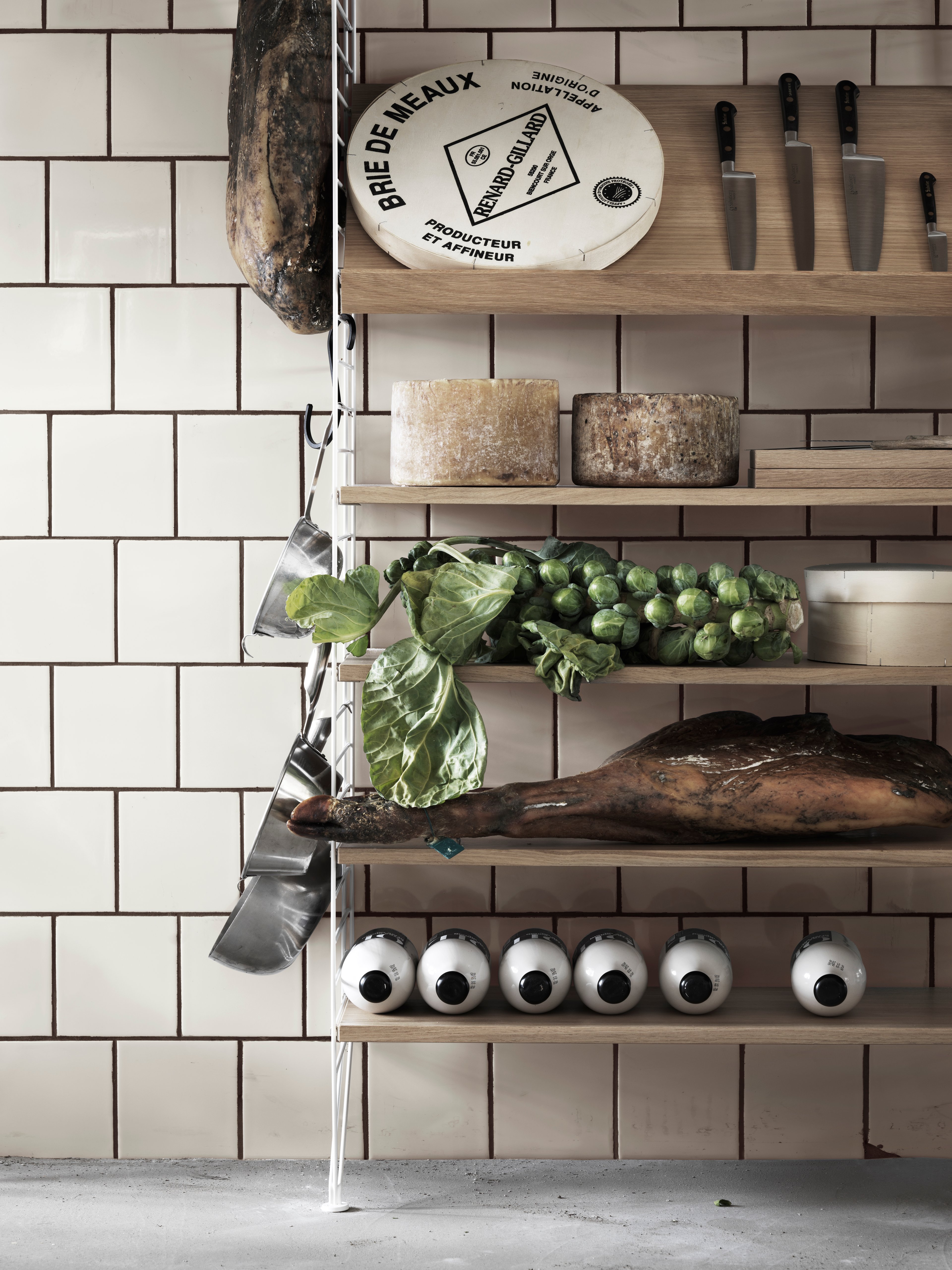 Floor mounted kitchen solution from String. Floor panels in white. Shelves and magazine shelf solid in oak.