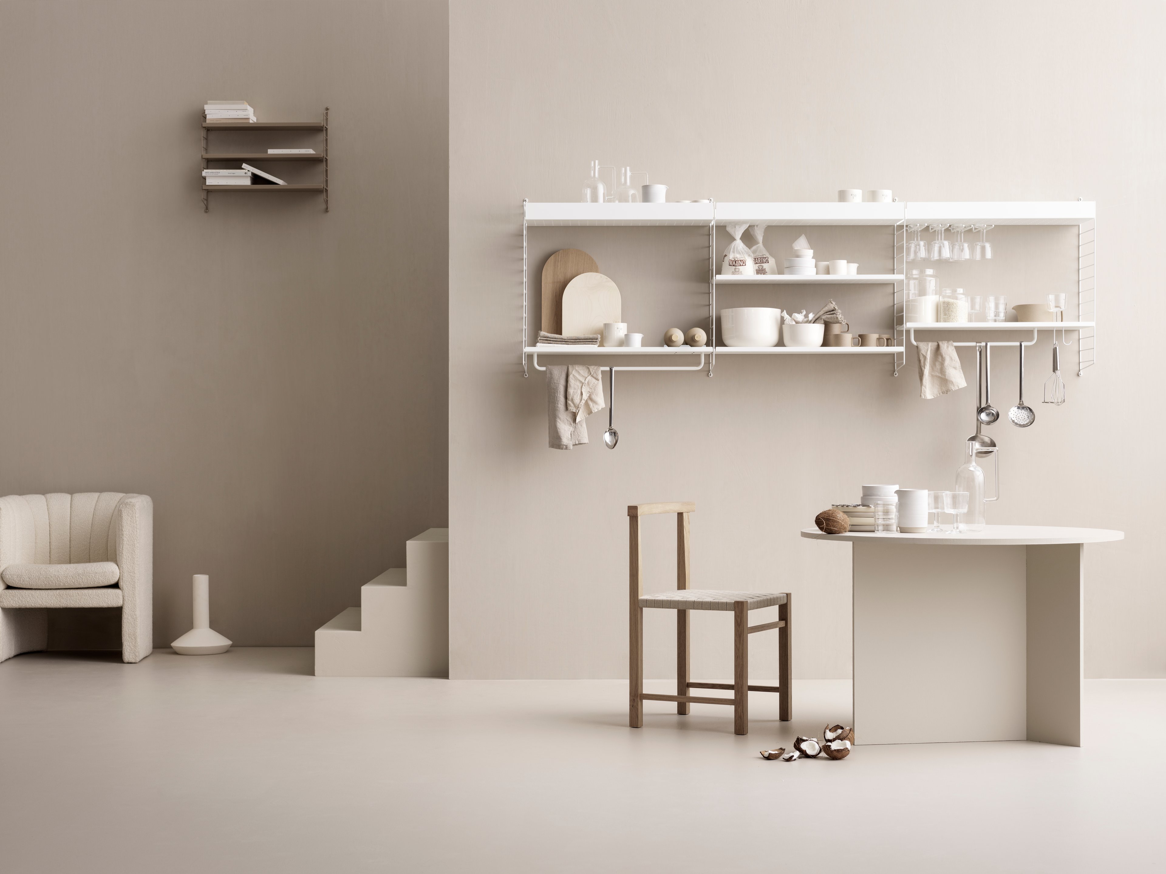 String shelving system for your kitchen. Wall panels in white, metal shelves with high and low edge in white, j hooks in white, hanger-racks in white and rods in white. String Pocket shelf with perforated metal shelves in the colour taupe.