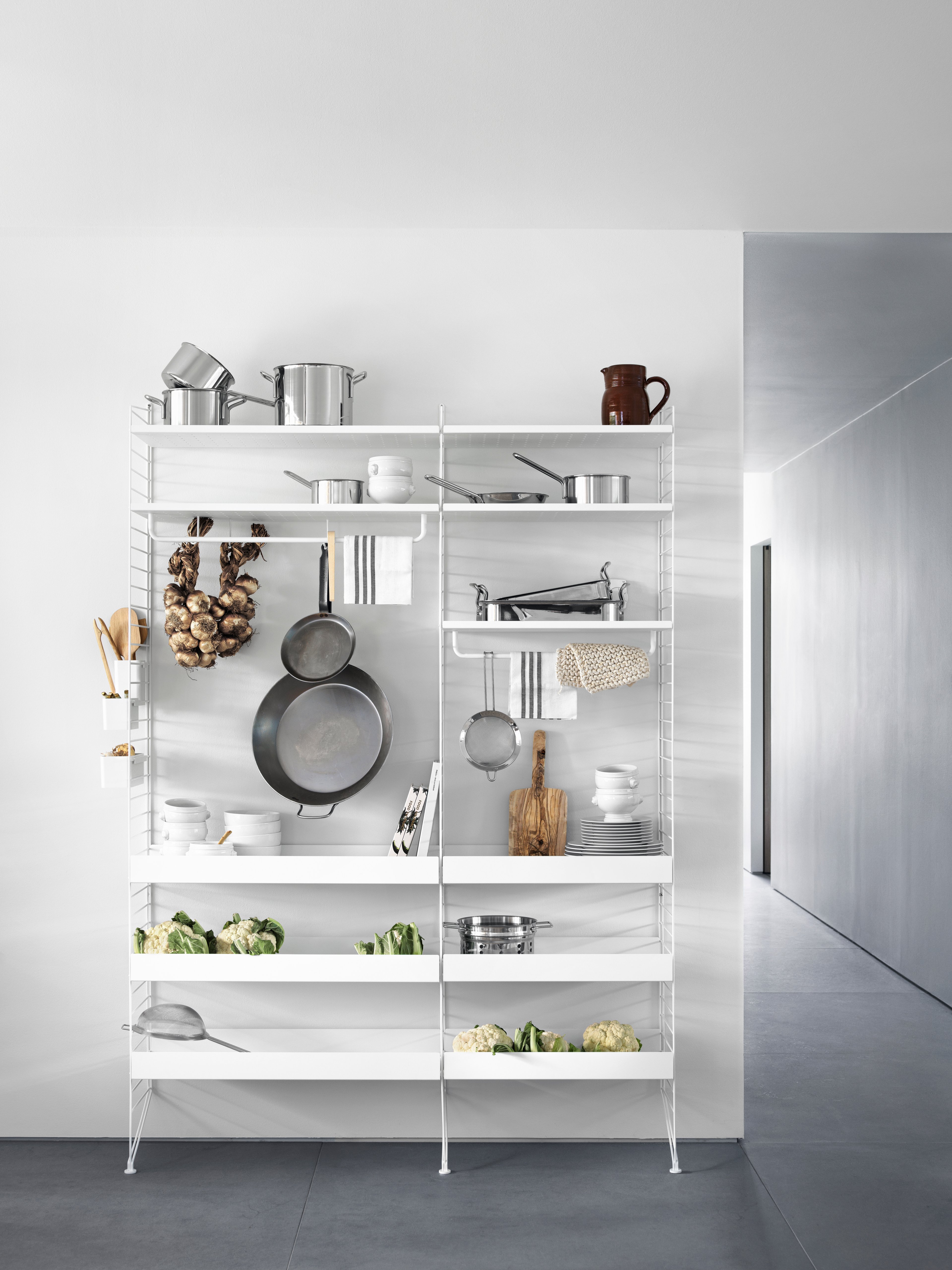 Floor mounted kitchen solution from String. Floor panels, metal shelves high and metal shelves low in white. Rods, hooks and organizers in white.
