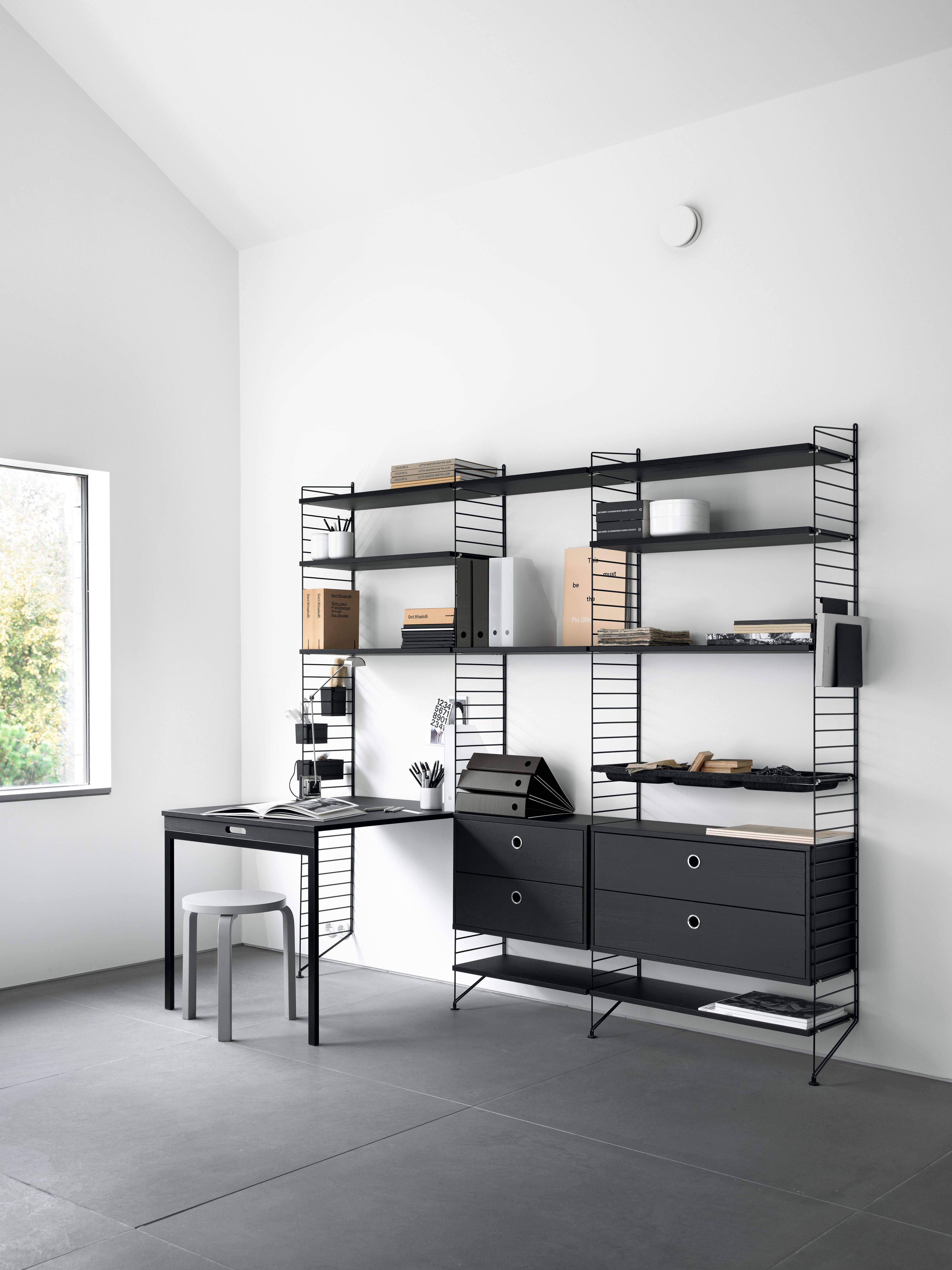 Floor mounted workspace solution from String. Floor panels in black. Shelves, chest of drawers and folding table in black stained ash.