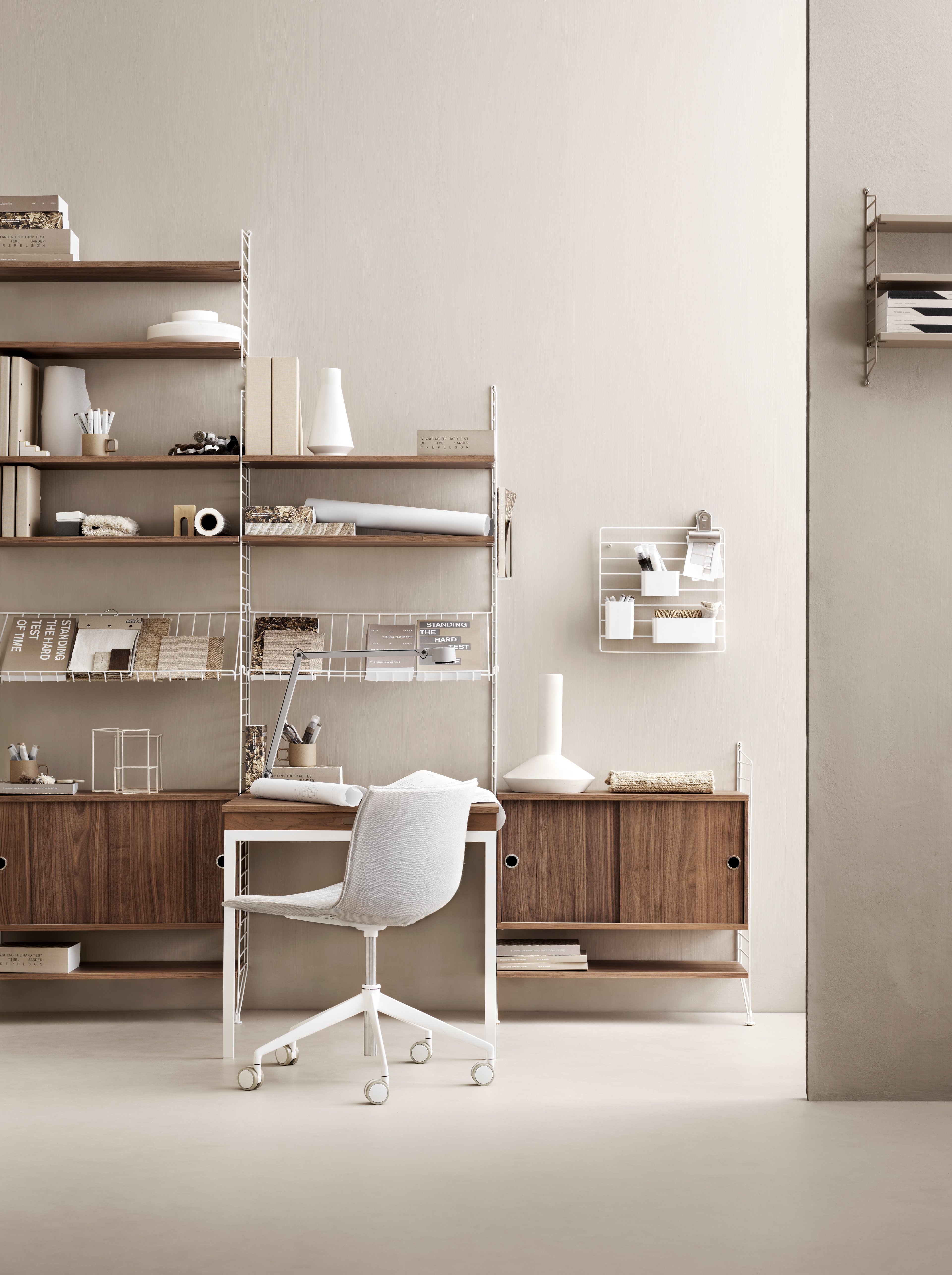 Floor panels in white. Shelves, cabinet with sliding doors and folding table in walnut. Grid for wall, magazine holder and organizers in white.