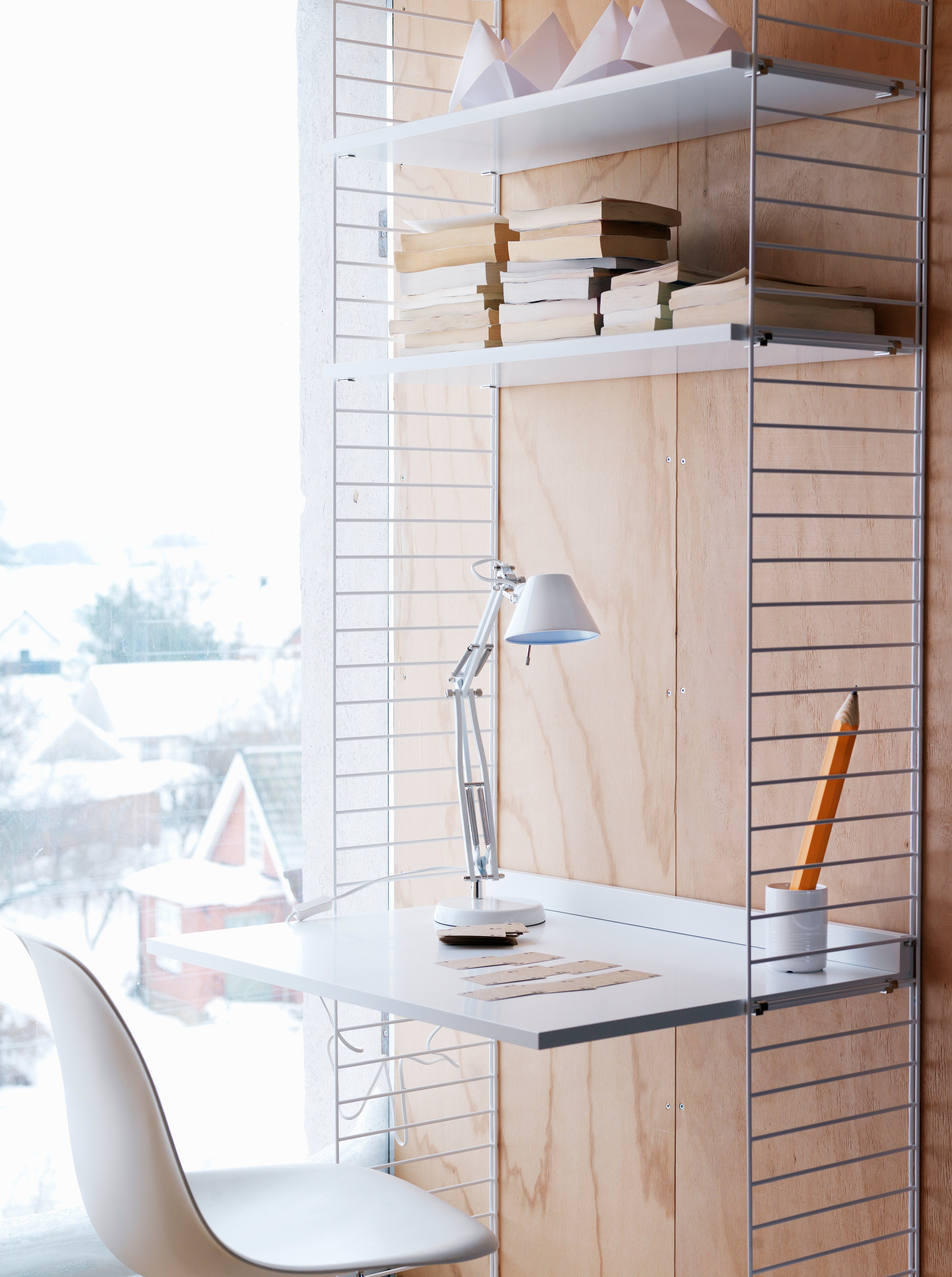 Floor mounted workspace solution from String. Floor panels, shelves and work desk in white.