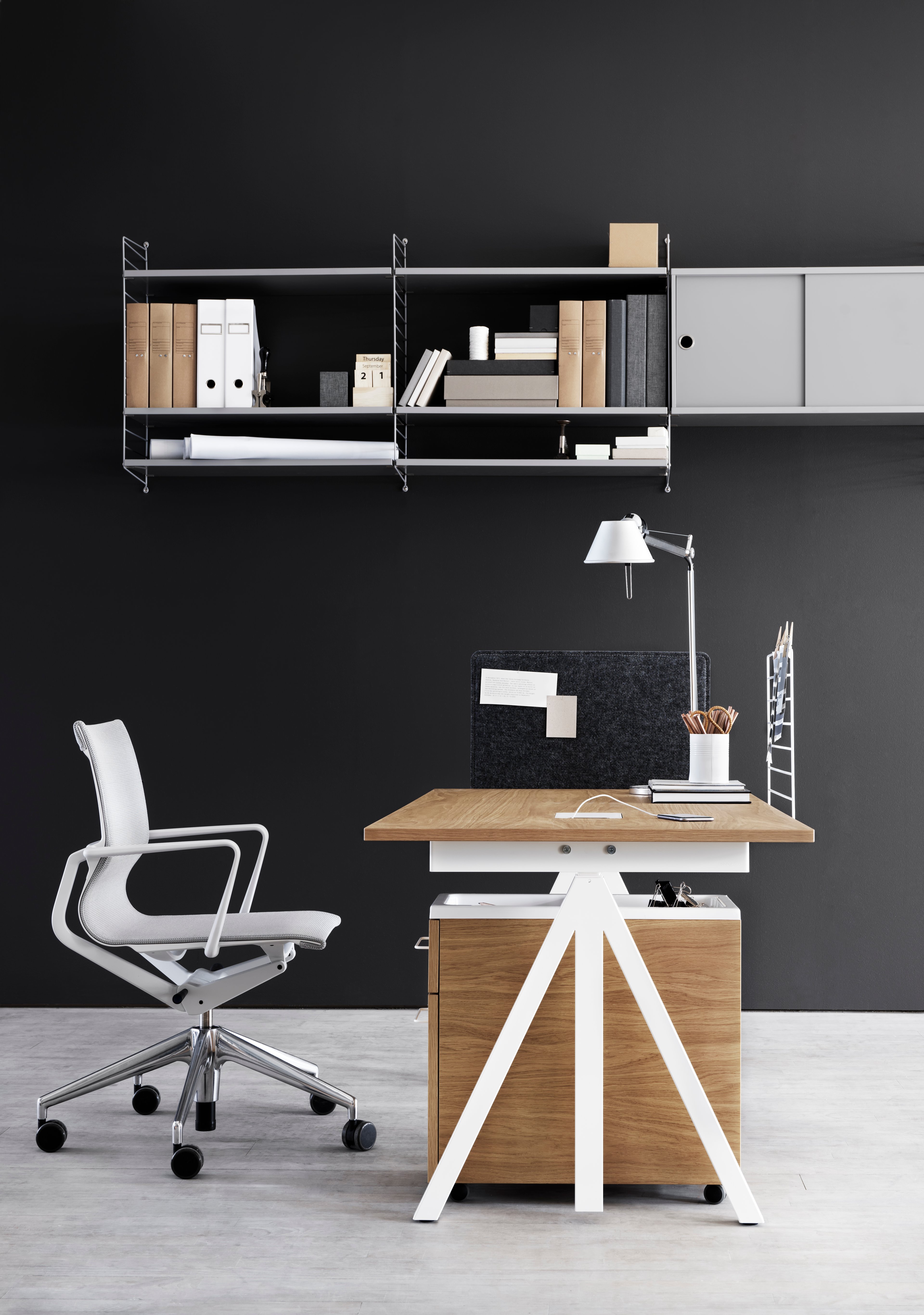 height-adjustable work desk in oak. mobile storage in oak. wire screen in white. fabric sleeve in grey felt. wall panels in grey. shelves and cabinets with sliding doors in grey.